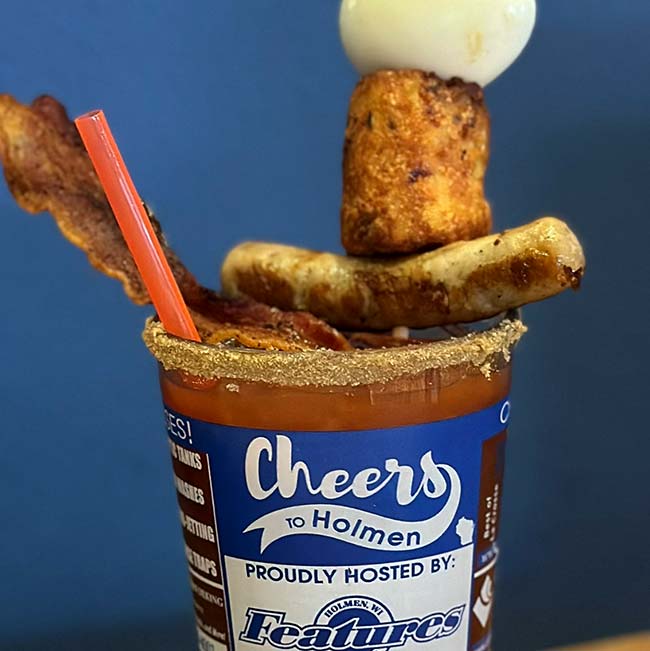 Bloody Mary topped with bacon, sausage, fried cheese—Features Sports Bar & Grill in Holmen, Wisconsin.