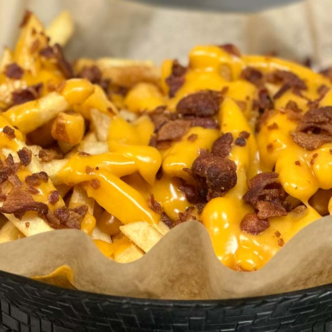 Restaurant-style French fries with melted cheddar and bacon, served in Holmen, Wisconsin bar.