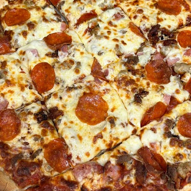 Close-up of square-cut pizza with cheese, pepperoni, sausage, and ham at a Holmen Wisconsin bar.