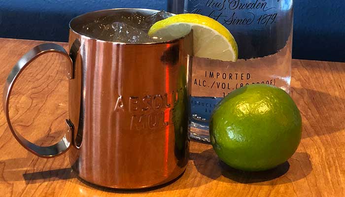 Copper mug with ice and lemon, a lime, and vodka bottle at a Holmen Wisconsin bar.