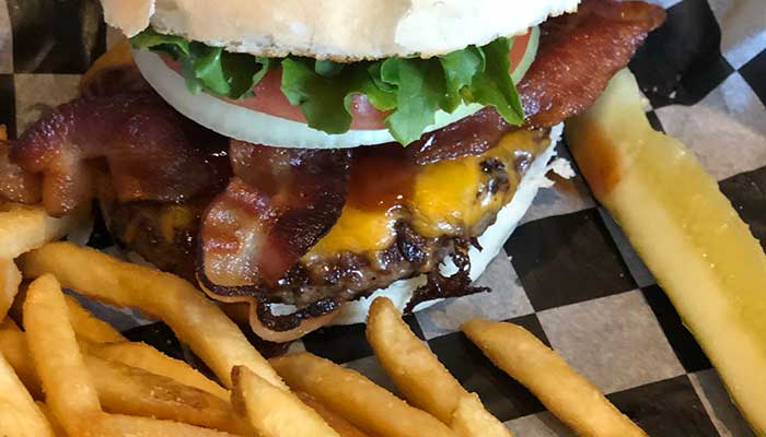 Bacon cheeseburger with fries and a pickle, served at our Holmen Wisconsin restaurant.