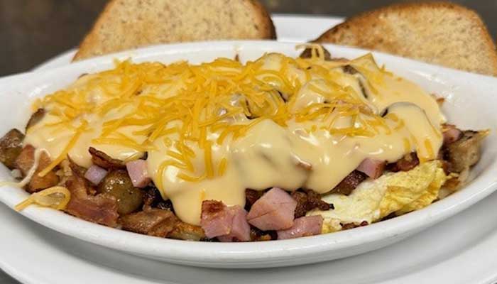 Egg omelet topped with cheese, ham, and sauce, served with toast at our Holmen Wisconsin bar.