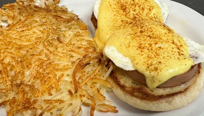 Eggs Benedict with hollandaise sauce and hash browns at Features Sports Bar & Grill.