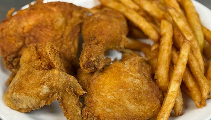 Fried chicken pieces and golden French fries served at a lively bar and restaurant.