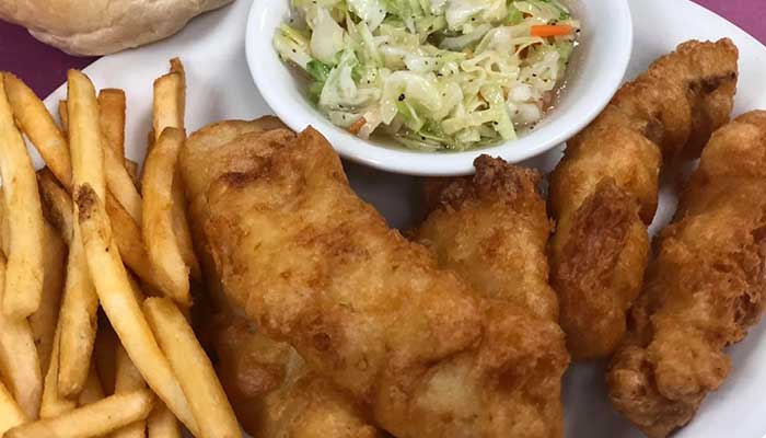 Plate with fried fish, French fries, and coleslaw—a classic Holmen Wisconsin bar food favorite.